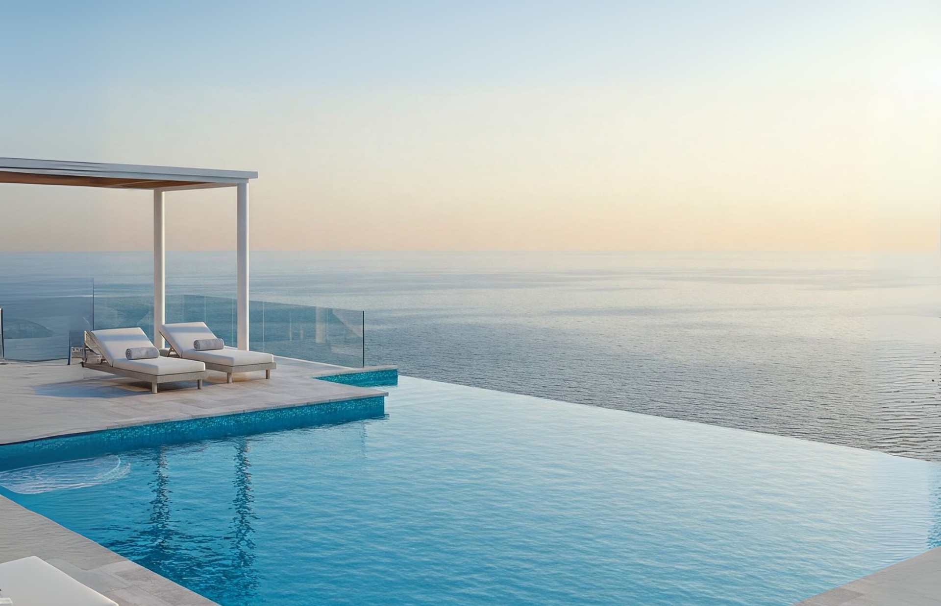 Infinity pool pergola overlooking the ocean at sunset
